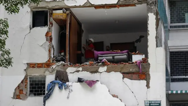 People check the damage at an apartment in Caracas