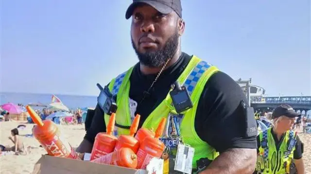 Police officer with box full of gas bottles