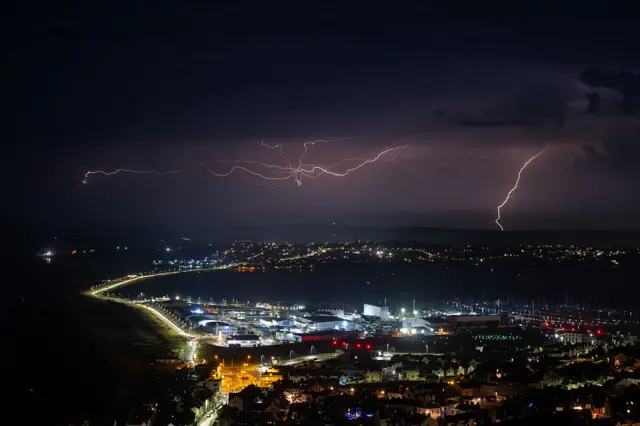 Lightning strikes are seen during a storm over Weymouth, on June 25, 2026