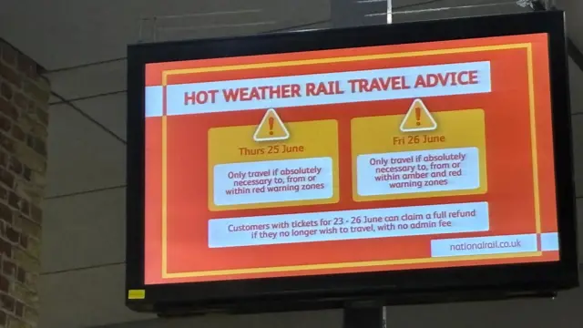 A screen at a railway station that says hot weather rail travel advice - only travel if absolutely necessary