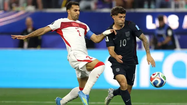 Christian Pulisic of the United States is challenged by Zeki Celik #2 of Turkiye during the FIFA World Cup 2026 Group D match between Türkiye and USA.