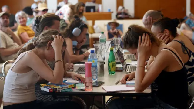 Middle school students work to prepare the "brevet des colleges" (middle school diploma) inside an air-conditioned room open to the public