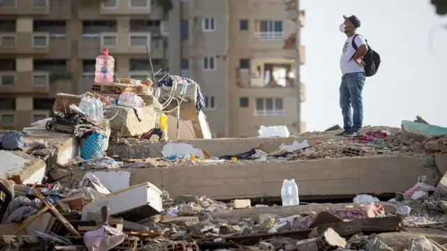 A man stands on the rubble of a damaged building in Catia La Mar, Venezuela, on 26 June 2026