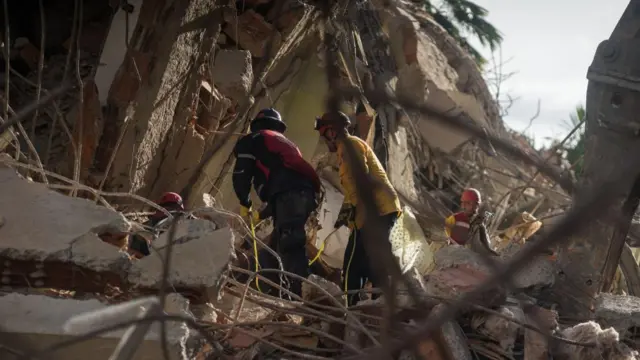 Rescue workers work at a building damaged by an earthquake in the Altamira area of Caracas