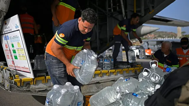 Aid workers transferring bottled water from a plane