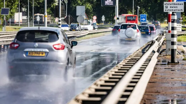 Vehicles drive along the Wantij Bridge, which is sprayed with water hoses, during a heatwave in Dordrecht, the Netherlands, 26 June 2026.