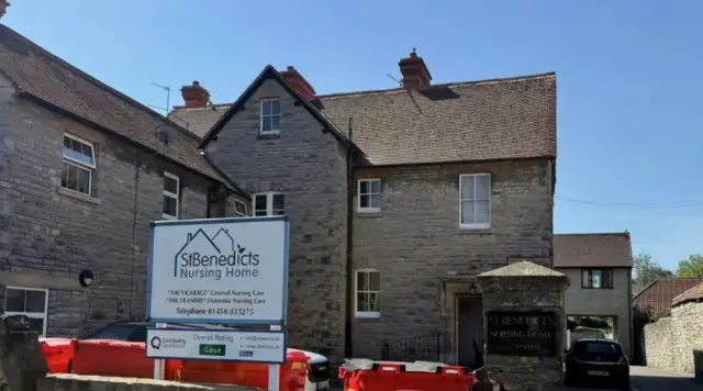 A sign says 'St Benedicts Nursing Home' outside the building