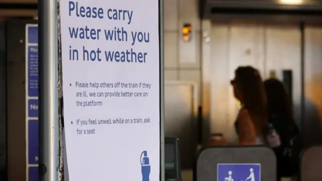 sign saying 'please carry water with you in hot weather' seen on london underground sign.