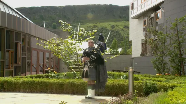 MSP Stuart McMillan playing the pipes