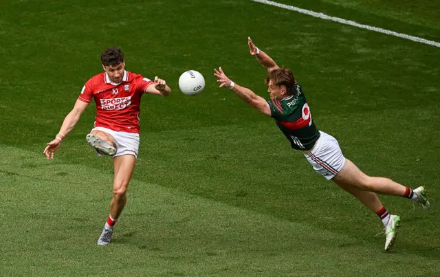 Paul Walsh of Cork scores a point despite the efforts of Jack Carney of Mayo