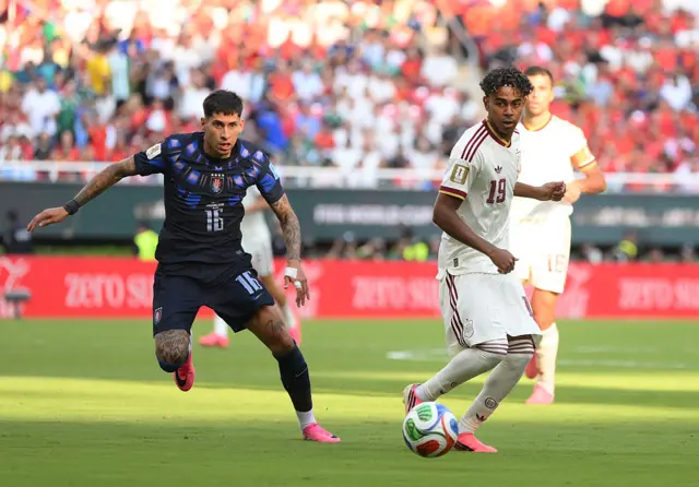 Lamine Yamal #19 of Spain and Mathias Olivera #16 of Uruguay compete for the ball