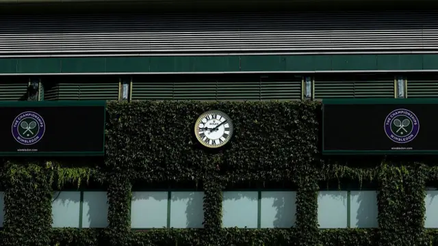 Clock and Wimbledon signs outside of court