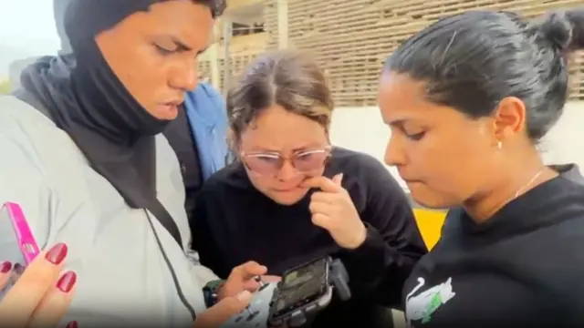A man controls a drone as people watch