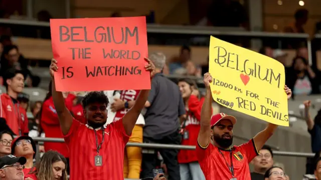 Belgium fans hold up banners saying 'Belgium the world is watching'