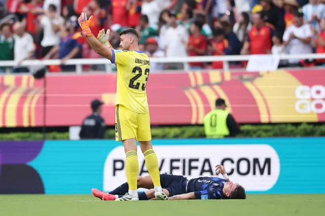 Manuel Ugarte #5 of Uruguay lies on the pitch while Unai Simon #23 of Spain calls medical attention