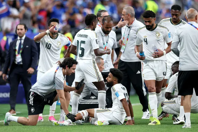 Nawaf Bu Washl #13 of Saudi Arabia is attended to by medical staff during a hydration break