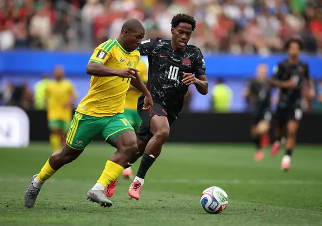 Mbekezeli Mbokasi battles for the ball with Jonathan David