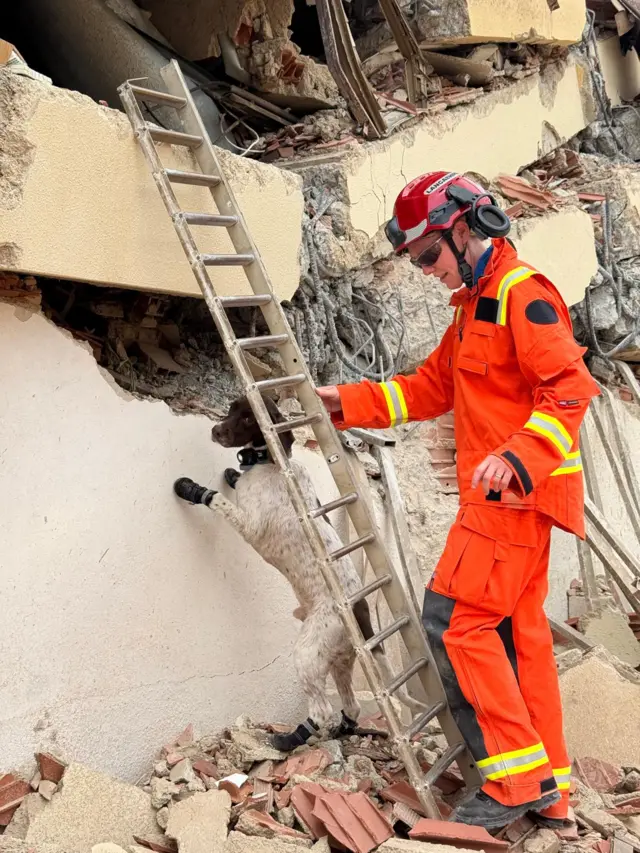 A UK Isar member searching through rubble