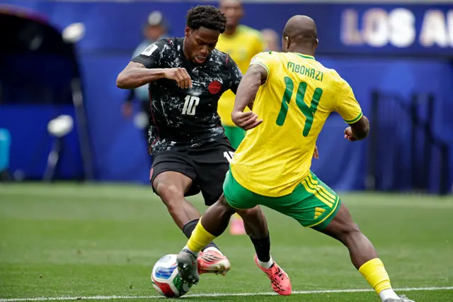 Jonathan David and Mbekezeli Mbokani battle for the ball