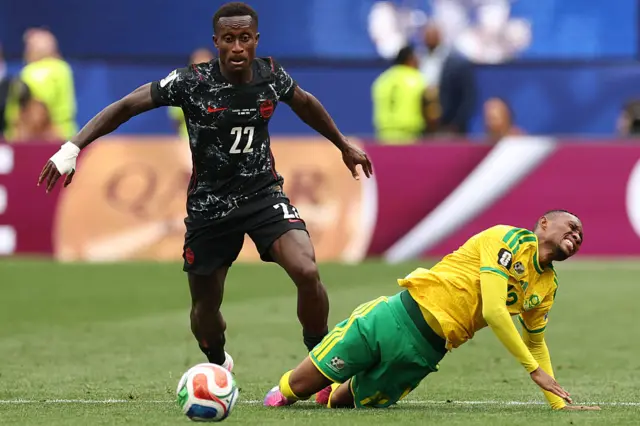 Thapelo Maseko falls on the ground past Canada's defender Richie Laryea