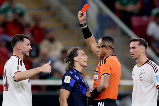 Referee Ismail Elfath shows Uruguay’s Agustín Canobbio a red card during the Group H match against Spain as players look on