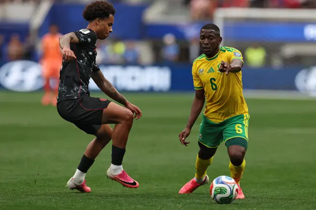 Aubrey Modiba runs with the ball past Canada's midfielder Tajon Buchanan
