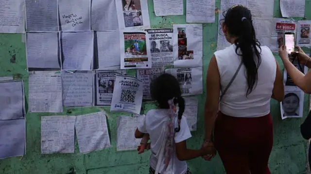 People look at a wall with photos and lists of names of missing people at Parque Ali Primera after a magnitude 7.2 earthquake struck Venezuela and other regions in the Caribbean on June 27, 2026 in Caracas, Venezuela