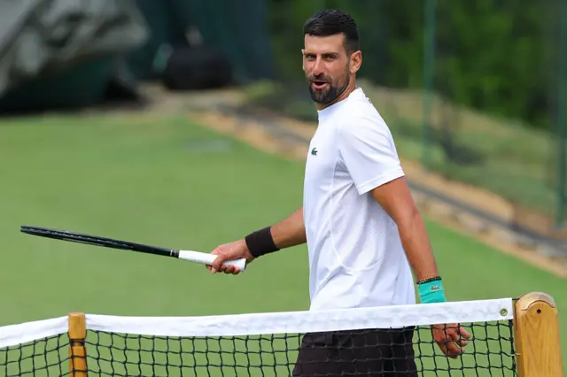 Novak Djokovic holds a tennis racquet