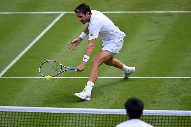 Cameron Norrie returns the ball at the net
