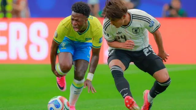 Vinicius Junior (L) of Brazil and Kaishu Sano (R) of Japan fight for the ball during the FIFA World Cup 2026 Round Of 32 match between Brazil and Japan.