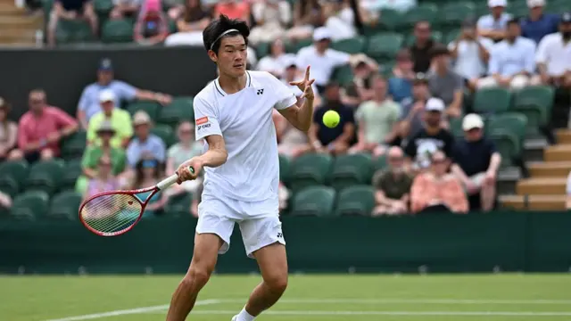 Michael Zheng returns the ball
