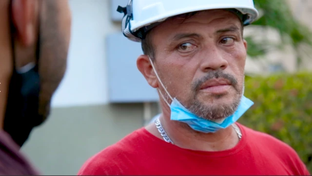 Ronnie Navarro wearing a white hard hat and blue mask around his chin