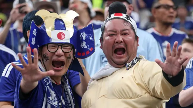 Two Japan fans one dressed in fun war gear and the other in a sumo wrestling costume