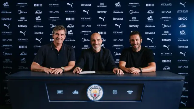 Enzo Maresca sitting between Hugo Viana and Ferran Soriano, signing his new contract as Manchester City manager.