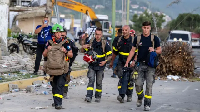 Members of the French Civil Security Training and Intervention Regiment (UIISC 7) walk in an area affected by building collapses in La Guaira state, Venezuela, on June 28, 2026, following earthquakes.