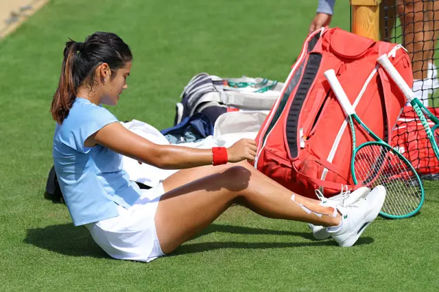 Emma Raducanu sits on grass