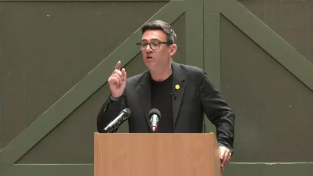 Andy Burnham raises his finger as he makes a speech in Manchester
