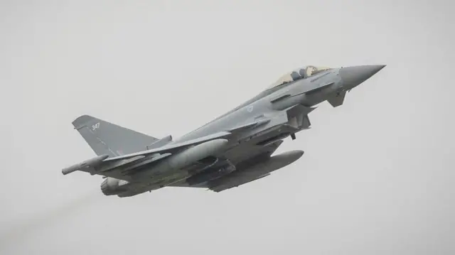 An RAF Typhoon aircraft against a cloudy sky.