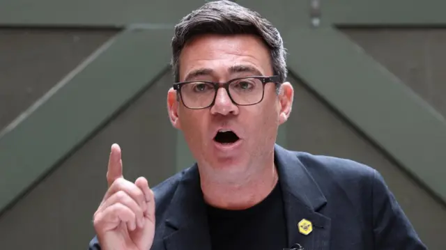 Andy Burnham holds his finger up as he speaks in Manchester