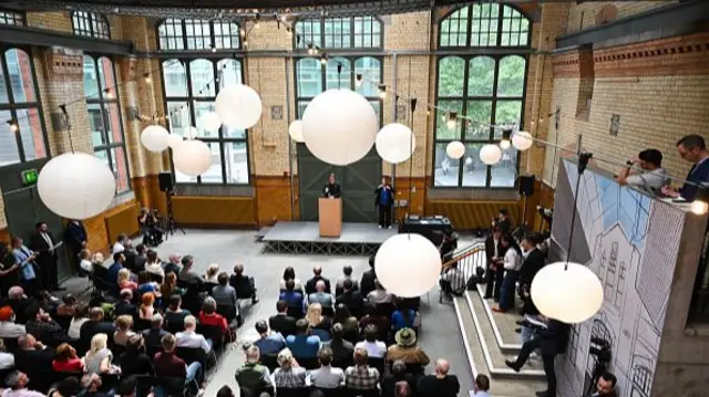 A crowded room watch as Andy Burnham delivers a speech at the People's History Museum in Manchester