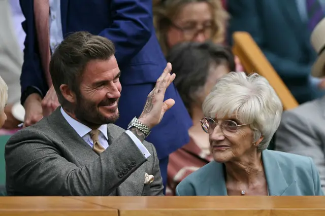 David Beckham waves, sat next to his mum in the Royal Box