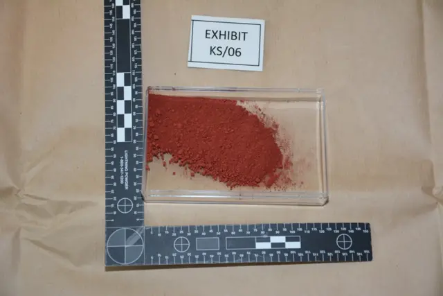 Thermite - a dark red powder in a shallow transparent evidence tray