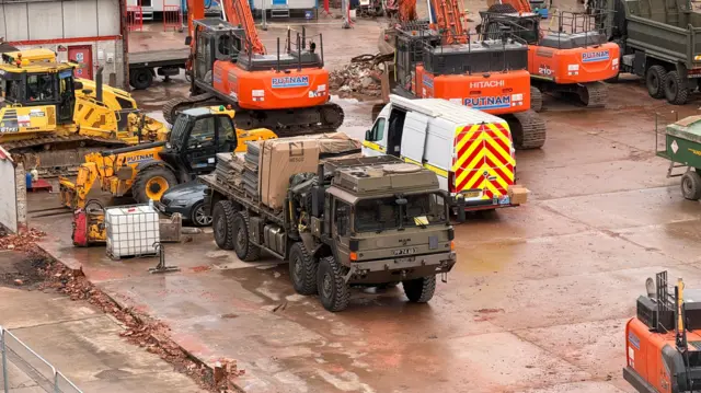 An army vehicle parked at the site with plant machinery surrounding it