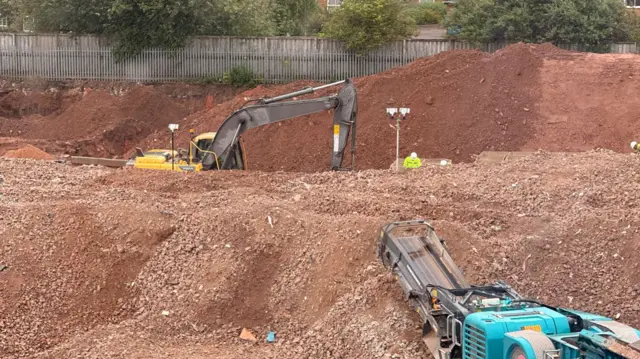 Two large vehicles on what could be a building site.