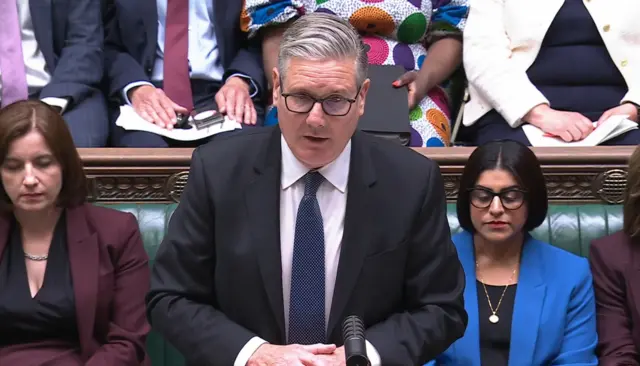 Starmer stands up in the House of Commons flanked by Bridget Philippson and Shabana Mahmood