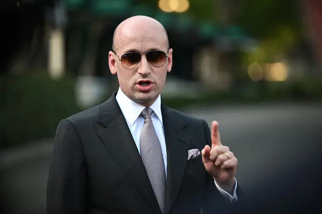 Stephen Miller wearing Aviator sunglasses and pointing upwards