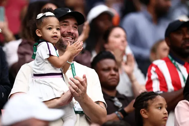 Serena Williams' husband Alexis Ohanian and her child Adira applaud