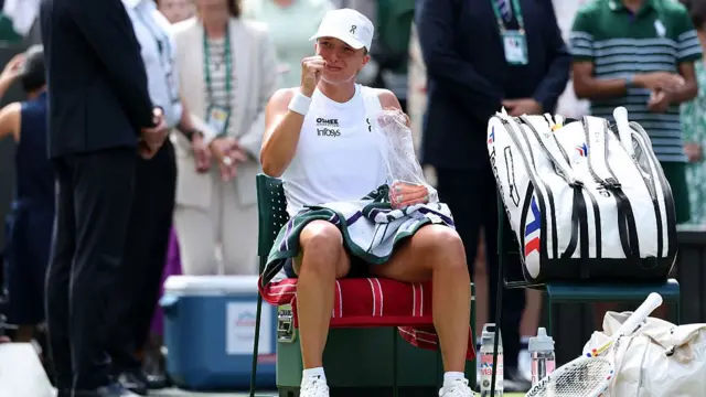 Iga Swiatek appears emotional as she sits in her seat after victory