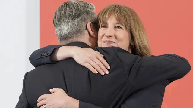 Britain's Prime Minister Keir Starmer hugs Chancellor of the Exchequer Rachel Reeves, on the day he delivers a speech, following the publication of long-delayed defence investment plan, in Berkshire, Britain, June 30, 2026