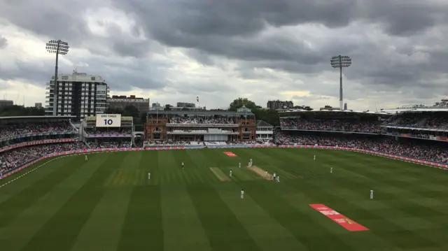 Lord's cricket ground shows grass and pavilion and cricketers